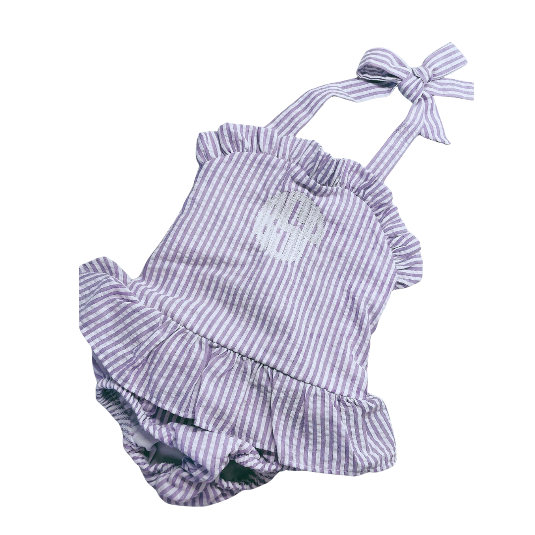 Purple and white striped baby romper with ruffled details on a white background
