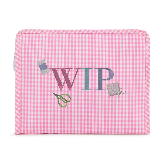 Pink gingham fabric with 'WIP' and sewing tools on a white background