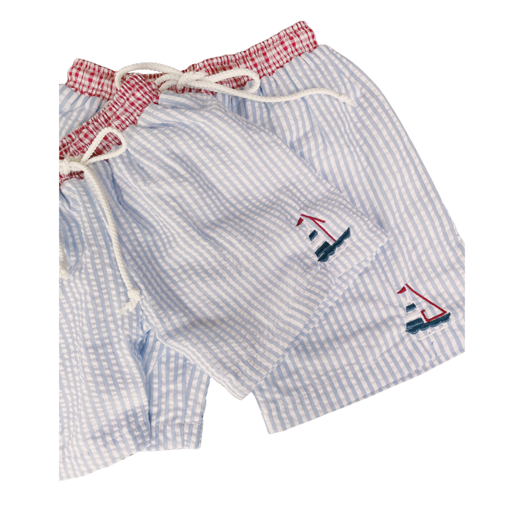 Blue checkered shorts with sailboat designs on a white background