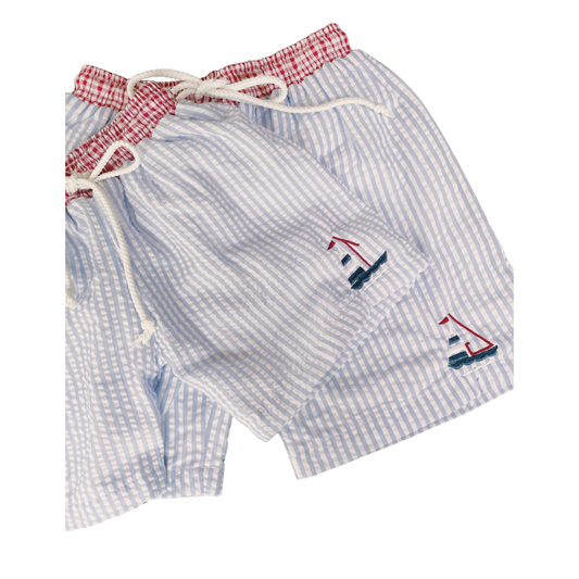 Blue checkered shorts with sailboat designs on a white background