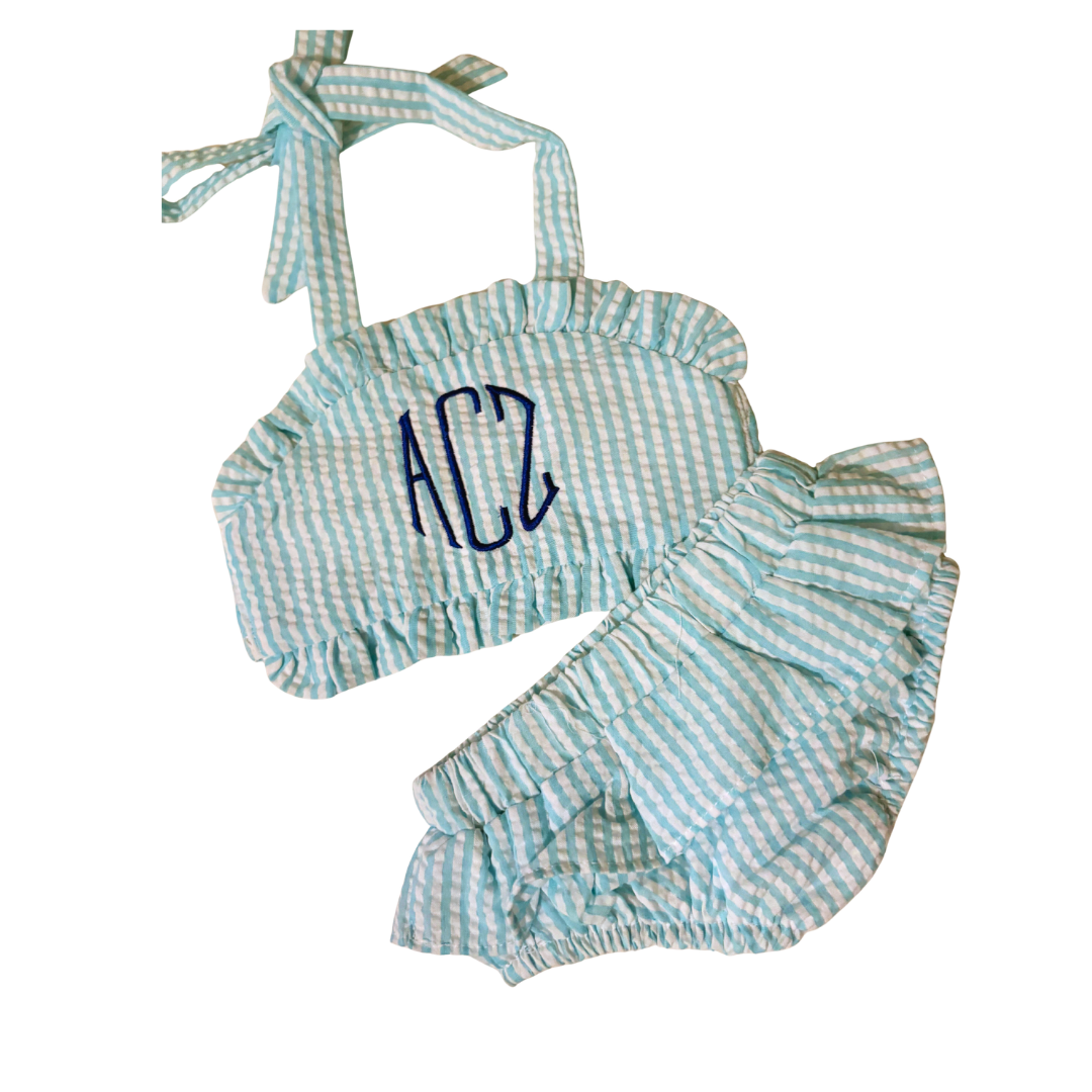 Children's outfit with blue and white striped top and shorts on a white background