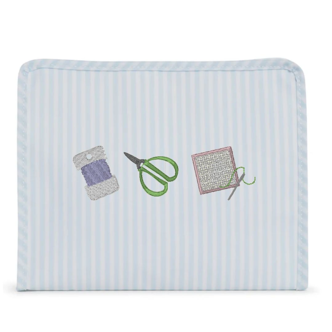 Rectangular fabric pouch with embroidered sewing tools on a light blue background