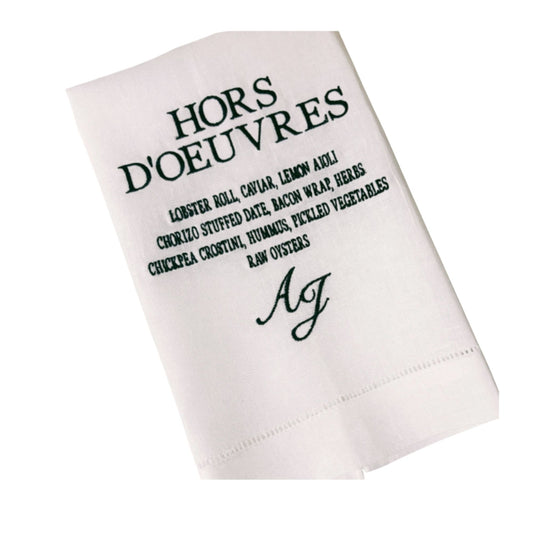 White napkin with black text and monogram on a white background
